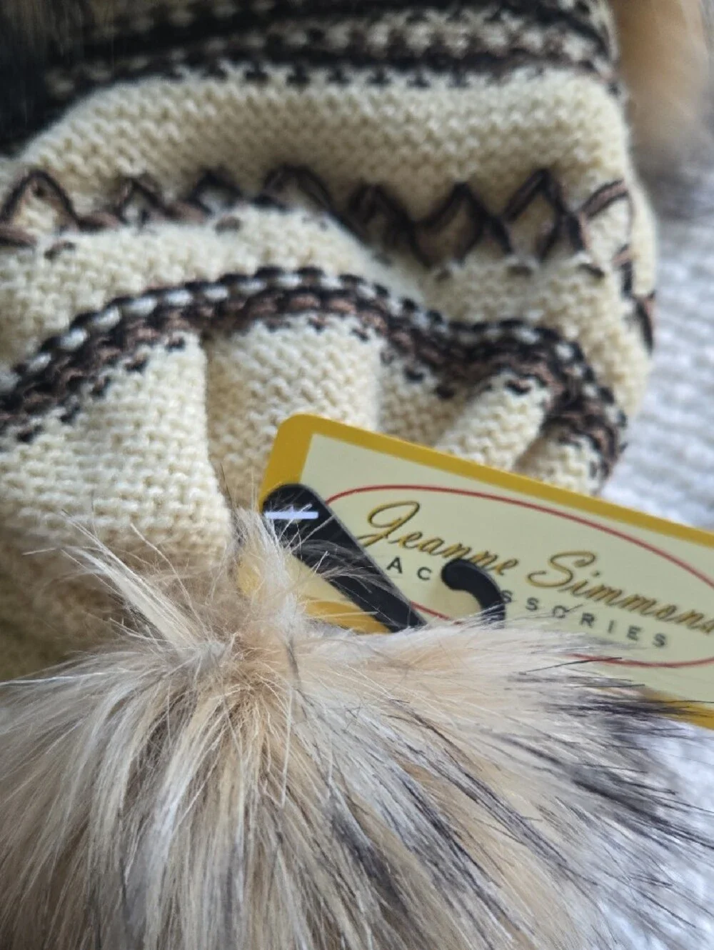 Cross stitch knit trapper beanie features a fleece lining, faux fur trim